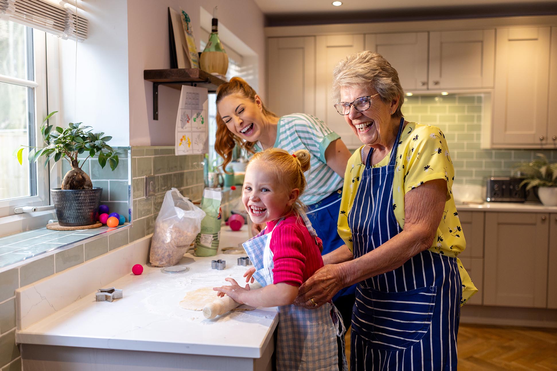 family of three generations enjoying cooking in the kitchen