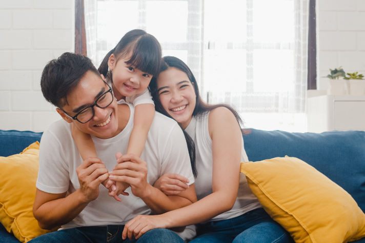 Our mission image of laughing family on couch