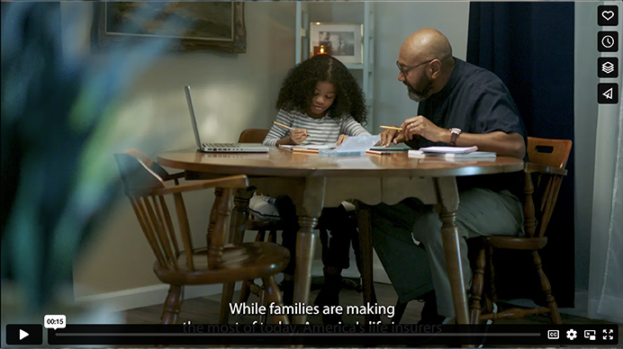 photo of a child and parent sitting at kitchen table doing homework